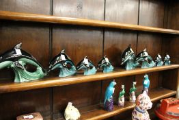 Two sets of Poole pottery dolphin families.