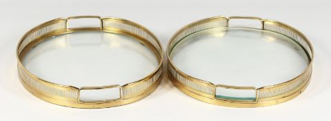 A pair of brass gallery trays with glass bases.