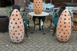 A large pair of terracotta garden floor standing lanterns with pierced star shaped decoration.