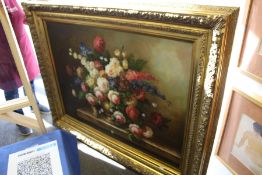 A still life of flowers in a vase on a ledge, oil on canvas, in a large decorative gilt frame.