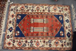 A Persian rug, central red ground decorated with two columns (some wear).