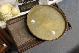 An eastern brass circular tray and two carved wood trays.