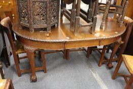 A mahogany extending dining table with one leaf on carved cabriole legs with claw and ball feet.
