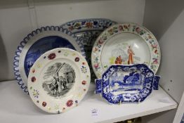 A blue and white circular plate depicting Doctor Syntax, a nursery plate and three other items.