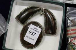 A Chinese carved horn brooch with white metal backing.