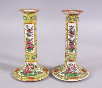 A PAIR OF 19TH CENTURY CHINESE CANTON FAMILLE JAUNE / ROSE CANDLESTICKS, decorated with panels of