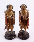 A PAIR OF 19TH CENTURY CHINESE CARVED WOOD AND LACQUER IMMORTAL FIGURES, each stood holding