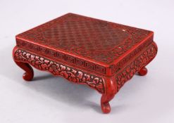 A 19TH CENTURY CHINESE CINNABAR LACQUER STAND, carved with a greek key and folate design, 13cm x