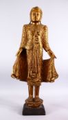 A LARGE INDIAN GILT WOOD INLAID FIGURE OF A DEITY, stood in an elegant pose in traditional gowns,