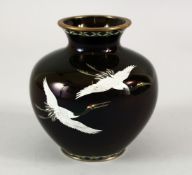 A JAPANESE MEIJI PERIOD BLACK GROUND CLOISONNE VASE, the black ground depicting three flying cranes,