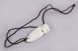 A CHINESE CARVED WHITE JADE DOG PENDANT, carved in the form of a lion / temple dog, 8cm