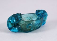 A CHINESE BLUE PEKING GLASS LIBATION CUP, with twin chilong handles, amongst lotus, 10cm.