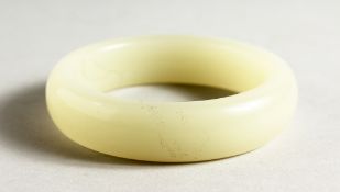 A WHITE JADE BANGLE. 3.25ins diameter.