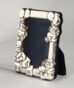 A SMALL SILVER PHOTOGRAPH FRAME, embossed with Teddy bears. 4ins x 3ins.