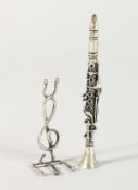 A MINIATURE SILVER CLARINET AND STAND.