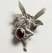 A SILVER FAIRY AND GARNET BROOCH.