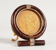 A CARTIER CIRCULAR PHOTOGRAPH FRAME in a bag. 2.75ins diameter.