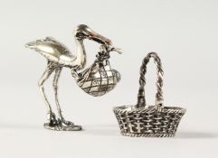 A MINIATURE SILVER STORK HOLDING A BABY WITH A BASKET.