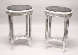 A PAIR OF FRENCH STYLE CARVED AND SILVERED WOOD LAMP TABLES, with oval marble tops. 2ft 4ins high