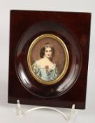AN OVAL PORTRAIT MINIATURE OF A YOUNG LADY in a wooden frame. 2.5ins x 2ins. Signed.
