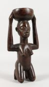 A NATIVE CARVED KNEELING FEMALE FIGURE. 10ins high.
