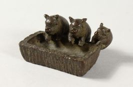 A MINIATURE BRONZE GROUP OF THREE PIGS AT A TROUGH.