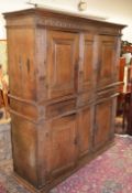 A 17TH CENTURY FOUR DOOR STANDING CUPBOARD, with carved and moulded cornice, central panels