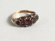 AN 18CT RUBY AND SEED PEARL SET FIVE-STONE RING.