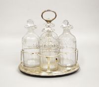 A GOOD GEORGE III OVAL FOUR BOTTLE CRUET, with four decanters and stoppers, the frame with gadrooned