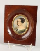 AN OVAL PORTRAIT MINIATURE OF A YOUNG LADY in a wooden frame. 2.75ins x 2ins. Signed.