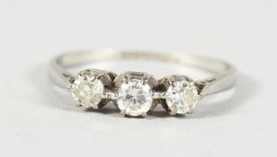 AN 18CT GOLD THREE STONE DIAMOND RING.