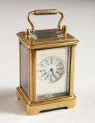 A MINIATURE BRASS CARRIAGE CLOCK with silvered front and Roman numerals. 2.25ins high.
