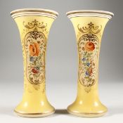 A PAIR OF YELLOW TRUMPET SHAPED VASES painted with flowers. 7ins high.