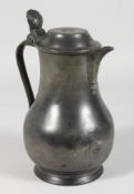 AN EARLY PEWTER LIDDED JUG, stamped MARTIN. 9.5ins high.