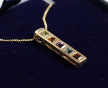 A 9CT GOLD PENDANT WITH PERIDOT, CITRINE, AMETHYST, BLUE TOPAZ AND GARNET, on a chain.
