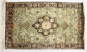A SMALL PERSIAN SILK RUG, 20TH CENTURY, with a central star shape motif and decorated with