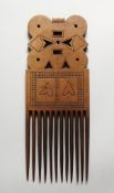 A TRIBAL CARVED WOOD COMB.