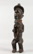 A LARGE CARVED TRIBAL MALE FIGURE. 16ins long.