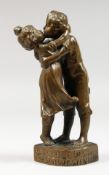 A SMALL BRONZE GROUP OF TWO CHILDREN KISSING. 