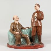 A RUSSIAN POTTERY GROUP, two figures, one seated. 13.5ins high.