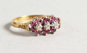 AN 18CT GOLD RUBY AND DIAMOND TRIPLE FLOWER HEAD RING.
