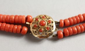 A TWO STRAND CORAL BEAD NECKLACE with 18ct gold clasp. 14ins long.