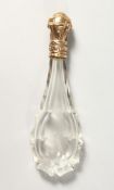 A CUT GLASS SCENT BOTTLE with an 18ct gold top.