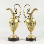 A GOOD PAIR OF 19TH CENTURY FRENCH ORMOLU EWERS, each with panels of cupids and mask spouts, on