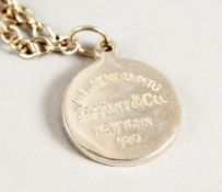 A TIFFANY SILVER PENDANT AND CHAIN in a Tiffany box.