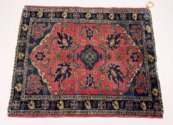 A SMALL PERSIAN RUG. mid 20th Century, red ground with stylized decoration. 3ft 3ins x 2ft 8ins.