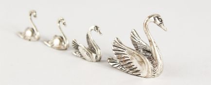 A GROUP OF FOUR MINIATURE SILVER SWANS.