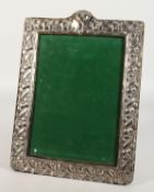 A GOOD UPRIGHT PHOTOGRAPH FRAME with floral borders. 14ins x 10ins.