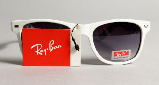 A PAIR OF NEW RAYBAN SUN GLASSES.