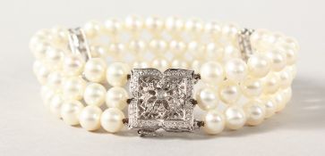 A GOOD WHITE GOLD TRIPLE ROW PEARL BRACELET with white gold and diamond clasp.
